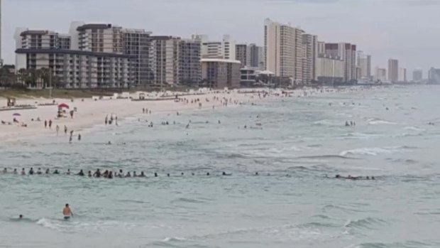 The beachgoers formed a human chain to rescue the stricken swimmers. 