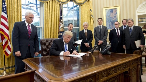 US President Donald Trump signs an executive order withdrawing from the Trans-Pacific Partnership.