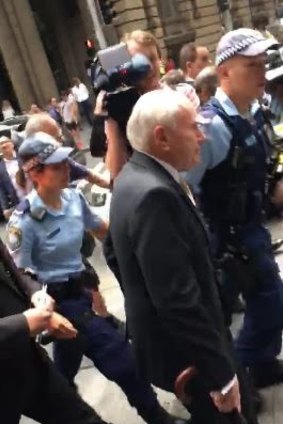 Police "came to the rescue" to move John Howard away from the protesters.