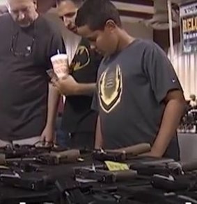A young boy looks at guns for sale at the Orlando gun show on Saturday.