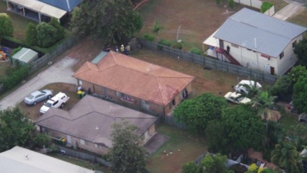 Police have established an exclusion zone around this house north of Ipswich, where negotiations with a man barricaded in a caravan are entering their seventh hour. 