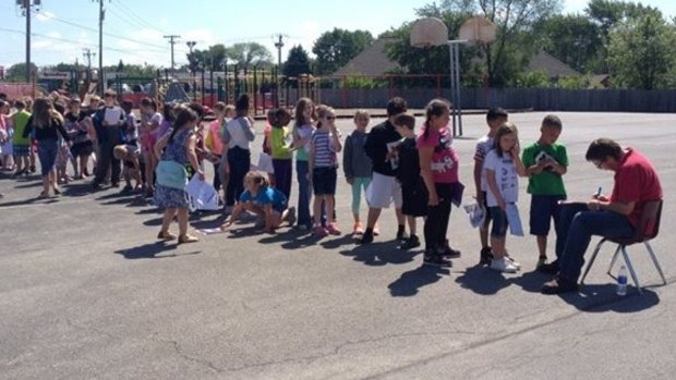 Students from Alan Shepard Elementary School in the US line up for an autograph from their janitor Steve Weidner. 