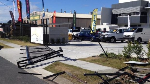 A fence was destroyed when thieves stole four cars from Nerang Car City.
