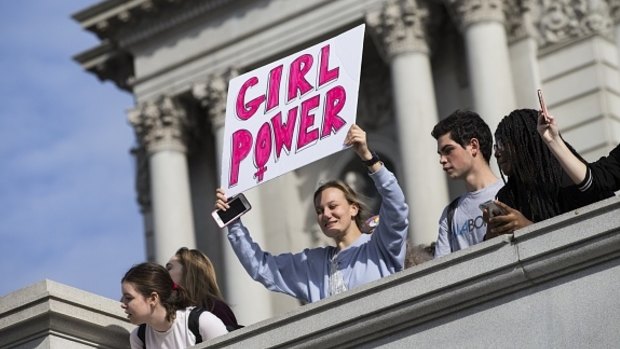 A girl holds banner as thousands of students march past the U.S. Capitol to protest President-elect Donald Trump in Washington on November 15, 2016. 