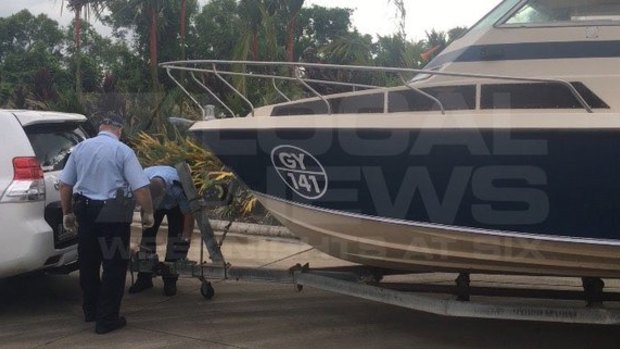 Police examine the boat that the five men towed from Melbourne to Cairns.