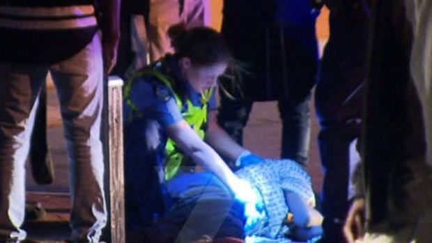 Police mind the injured teenager after the Girrawheen incident.