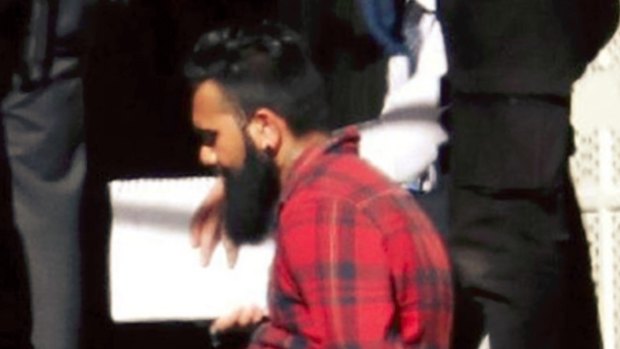 A bearded man in a red shirt who was arrested by police was filming the Flinders Street attack.
