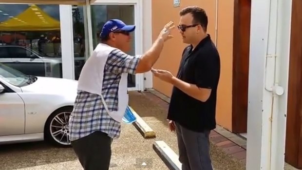 LNP MP Ray Stevens dances and flaps in front of a reporter on the Gold Coast.