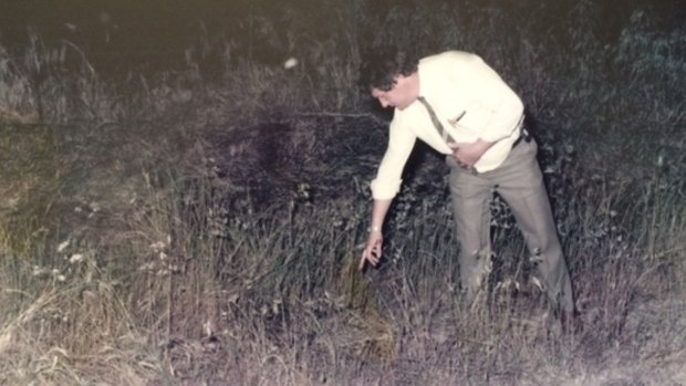 A police officer points to the spot where Michelle's necklace was found.