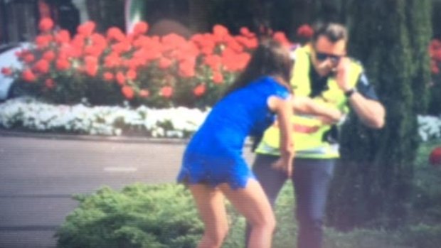 A young woman pushes Acting Superintendent Steven Cooper into a bush at Flemington.