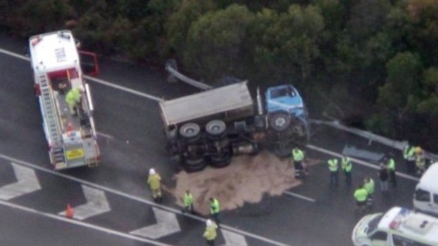 The clean-up begins after a truck rollover on the Mt Lindesay Highway, south of Brisbane.