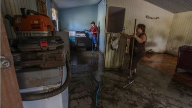 Marie Turner-Gomez helps with the clean up at Russell Keys flood-devastated
home on Brisbane Terrace, Goodna.