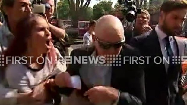 Adrian Attwater (in sunglasses) is confronted outside Grafton Local Court last year. 