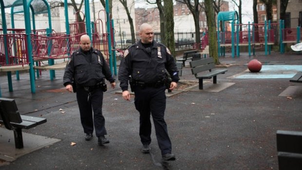 Police officers on Sunday cross Osborn Playground in the Brownsville section of Brooklyn, where an 18-year-old woman was raped by five young men.
