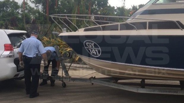 Police examine the boat that the five men towed from Melbourne to Cairns.
