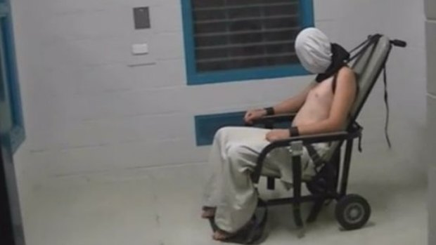 A teenage Dylan Voller has a hood placed over his head and is strapped to a chair at the Don Dale Detention Centre.