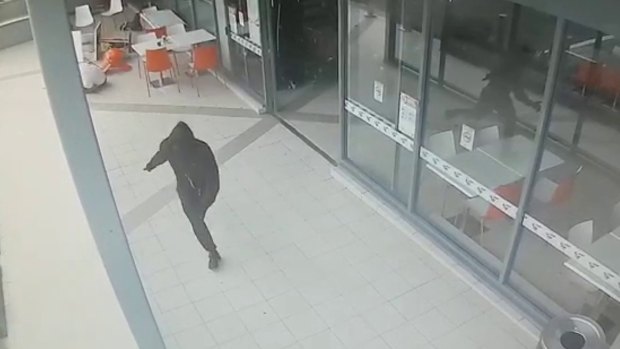 A hooded figure runs from Bankstown Central after shooting Wally Ahmad on April 29, 2016.