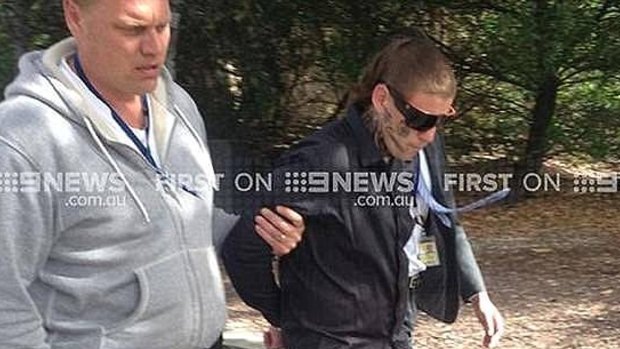 Bradley Azzopardi is brought into court in Geelong last year, the words "No Comment" tattooed on his face.