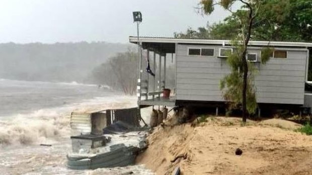 A home gradually collapses off a sandback on Great Keppel Island as Tropical Cyclone Marcia approaches the coast. 