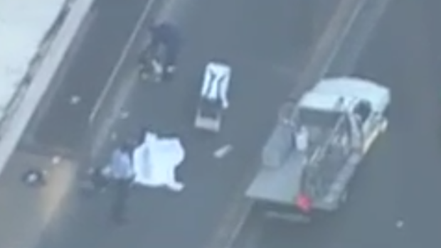 Paramedics at the scene of the Parramatta shooting attending to one of the two bodies.