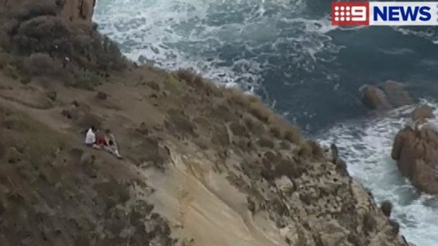 The couple sat on the cliff until they could be pulled to safety.
