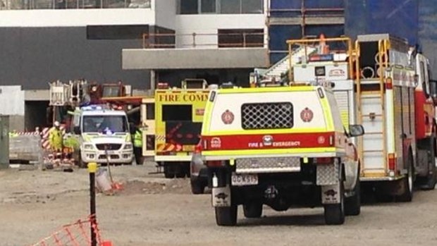 Emergency crews work to free a man from a water tank at Biggera Waters.