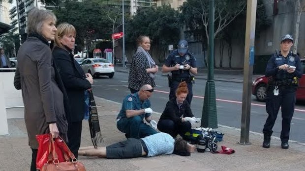Paramedics treat a man apparently coward punched on Ann Street in the Brisbane CBD.