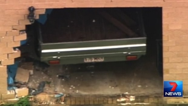 A car is visible at a house at Delaneys Creek, north-west of Brisbane, where a man allegedly rammed through a wall and stabbed another man to death.
