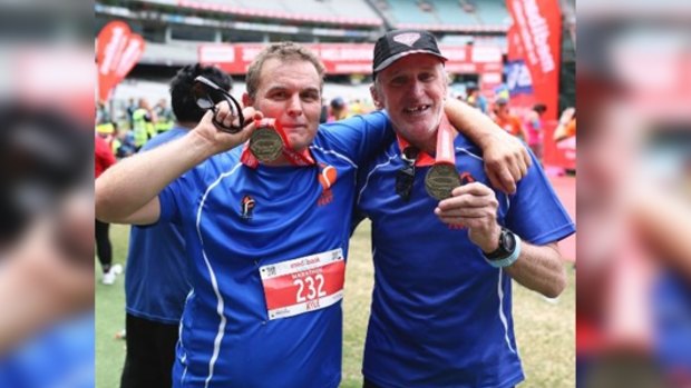 Homeless runners Kyle Holtzman and Ian Brown Brown display their medals after completed the Melbourne Marathon.  