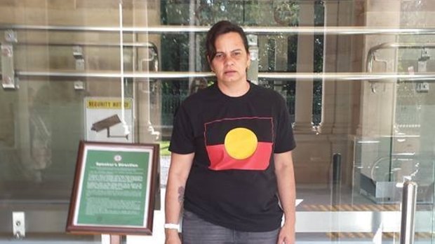 Janine Kelly was forced to cover up the Aboriginal flag on her T-shirt to enter Queensland's Parliament House on Tuesday.