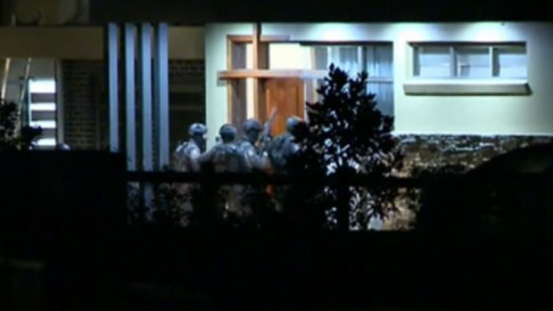 Tactical Operations Unit officers enter a home in Luddenham about midnight.