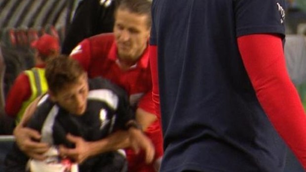 Adelaide United's Michael Marrone grabs a ball boy during the FFA Cup final against Sydney FC.