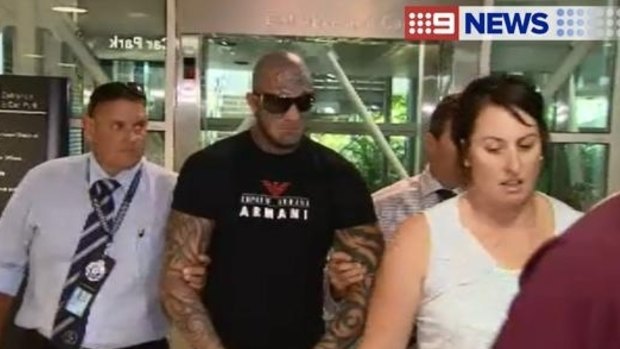 Alleged bikie Brett Pechey is taken into custody at Brisbane Airport.