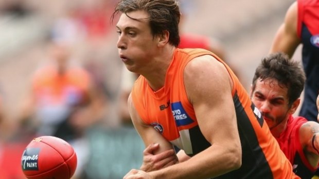 Caleb Marchbank handballs during the round-one match between the GWS Giants and Melbourne at the MCG.