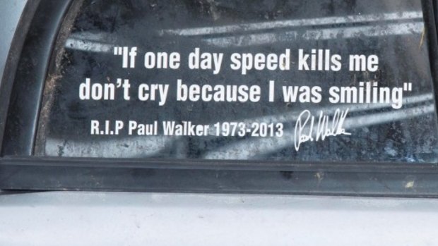 The grim bumper sticker on the wrecked car from a crash that killed back-seat passenger Jesse Uncles.