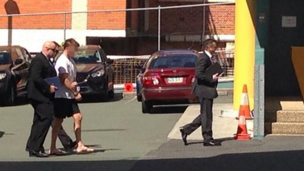 Detectives lead a handcuffed Gable Tostee to the watchhouse.