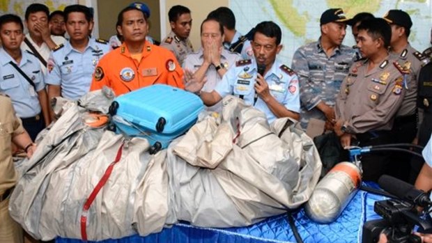 Airplane parts and a suitcase found floating on the water near the site where AirAsia flight 8501 disappeared.  
