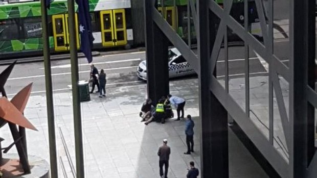 Police treating a person in Melbourne's CBD.