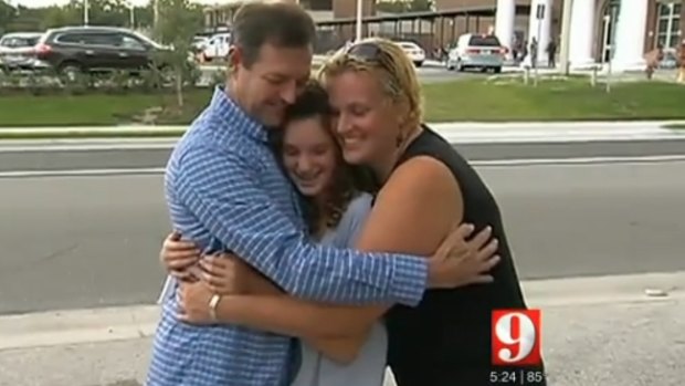 Florida schoolgirl Ella Fishbough gets a hug from her parents.