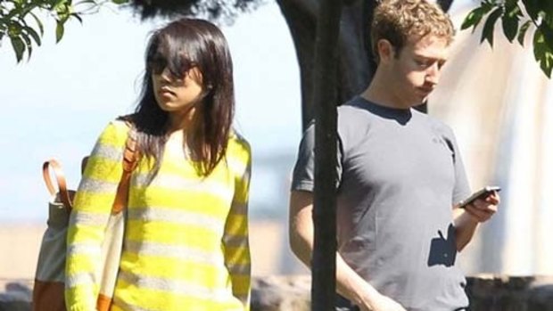 Mark Zuckerburg can't resist checking his phone while out with his wife Priscilla Chan
