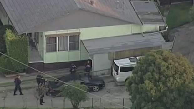 Heavily armed police surround a black sedan in Doveton.