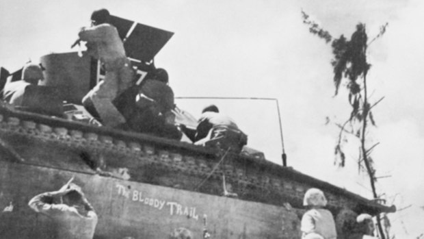 Peleliu, Palau Islands,1943. US Marines from III Corps taking shelter behind an amphibious tractor on the beach-head as Japanese resistance to the Allied invasion increases. 