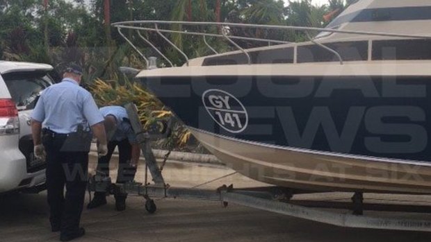 Police examine the boat that the five men towed from Melbourne to Cairns.