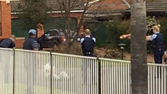 Police point Tasers at Ihsas Khan as he sits on the ground.