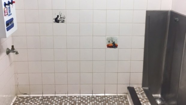 A photograph supplied by ACT Labor politician Bec Cody of the  men's urinal at the Sussex Inlet RSL, with tiles depicting Aboriginal men.