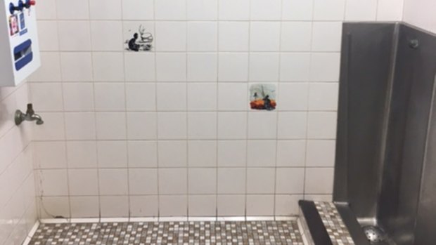 A photograph supplied by ACT Labor politician Bec Cody of the  men's urinal at the Sussex Inlet RSL, with tiles depicting Aboriginal men.