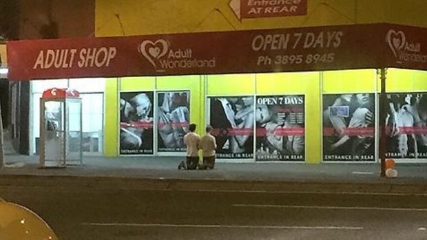 A photo showing two men praying outside a Brisbane adult shop on Tuesday night have Reddit users perplexed.