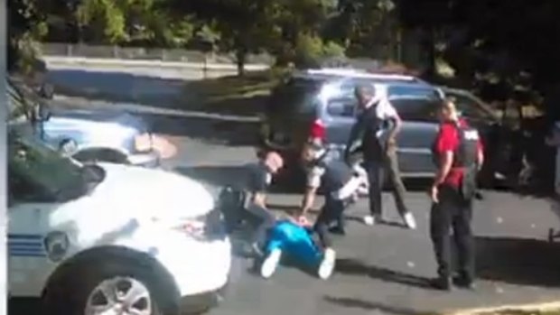 A still from the video showing Scott mortally wounded, surrounded by police.