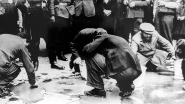 Jews in Vienna forced to scrub Schuschnigg's slogans off the sidewalk as Nazi soldiers watch.