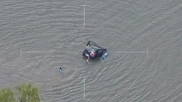 Police helicopters capture the rescue of a woman from a sinking car in the Georges River.